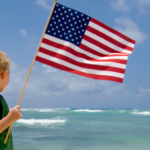 child with usa flag by ocean