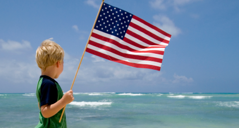 child with usa flag by ocean