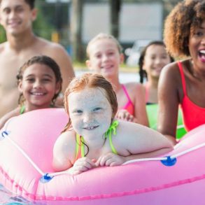 family at water park with inner tubes on lazy river