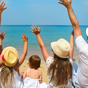 family of five sitting on the beach