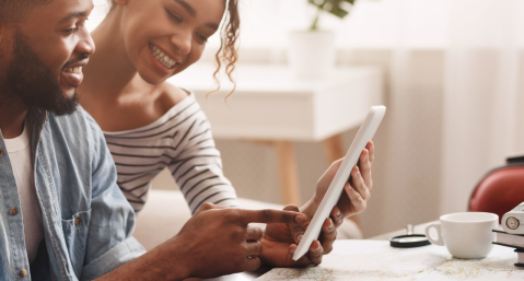 couple look at iPad planning vacation